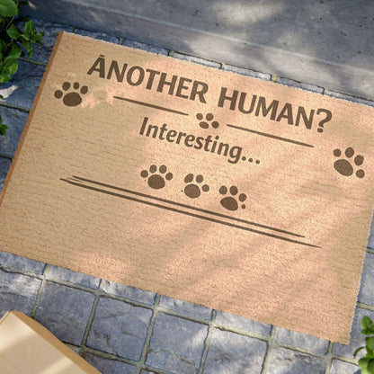 Close-up angled view of “Another Human? Interesting…” cat doormat, highlighting playful design and witty message.