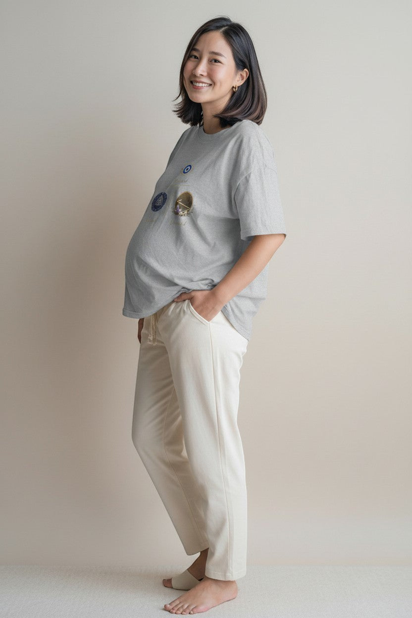 Woman wearing grey graphic t-shirt with symbolic artwork, styled for a relaxed and comfortable look.