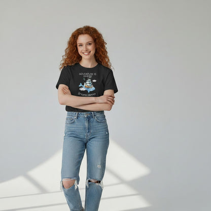 Jena Jewelry black cotton t-shirt with "Adventure Is Where Dreams Happen" graphic featuring a whale, ship, lighthouse, and clouds.