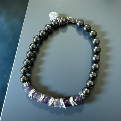 Jena Jewelry amethyst and magnetic hematite stretch bracelet with silver accents. Features purple amethyst beads and dark grey hematite beads.