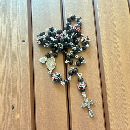 Jena Jewelry hand-wrapped rosary with black obsidian beads and floral lampwork glass beads, featuring a base metal crucifix and medallion.