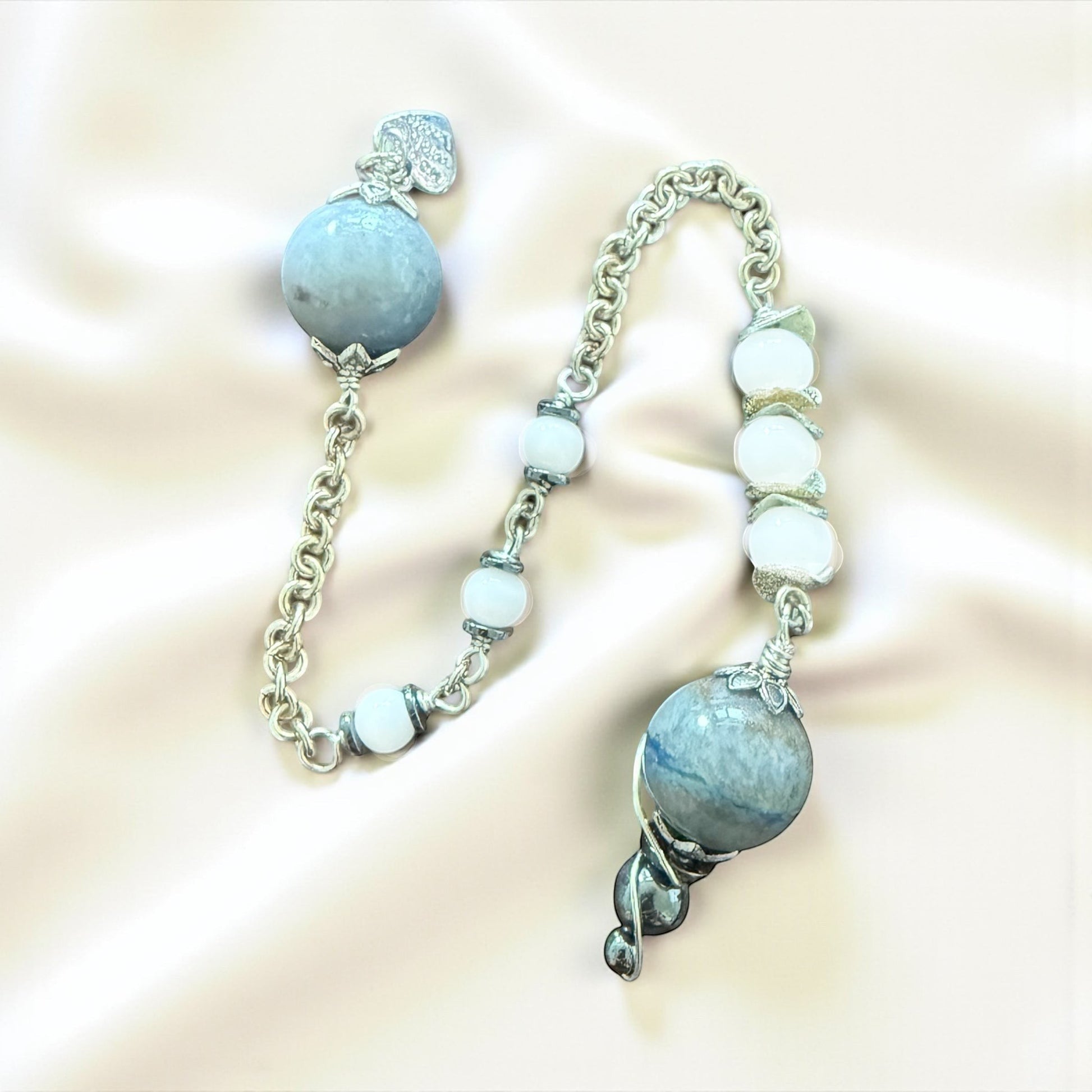 Jena Jewelry pendulum with blue aventurine, snow jade, and hematite beads on a silver chainmaille handle.