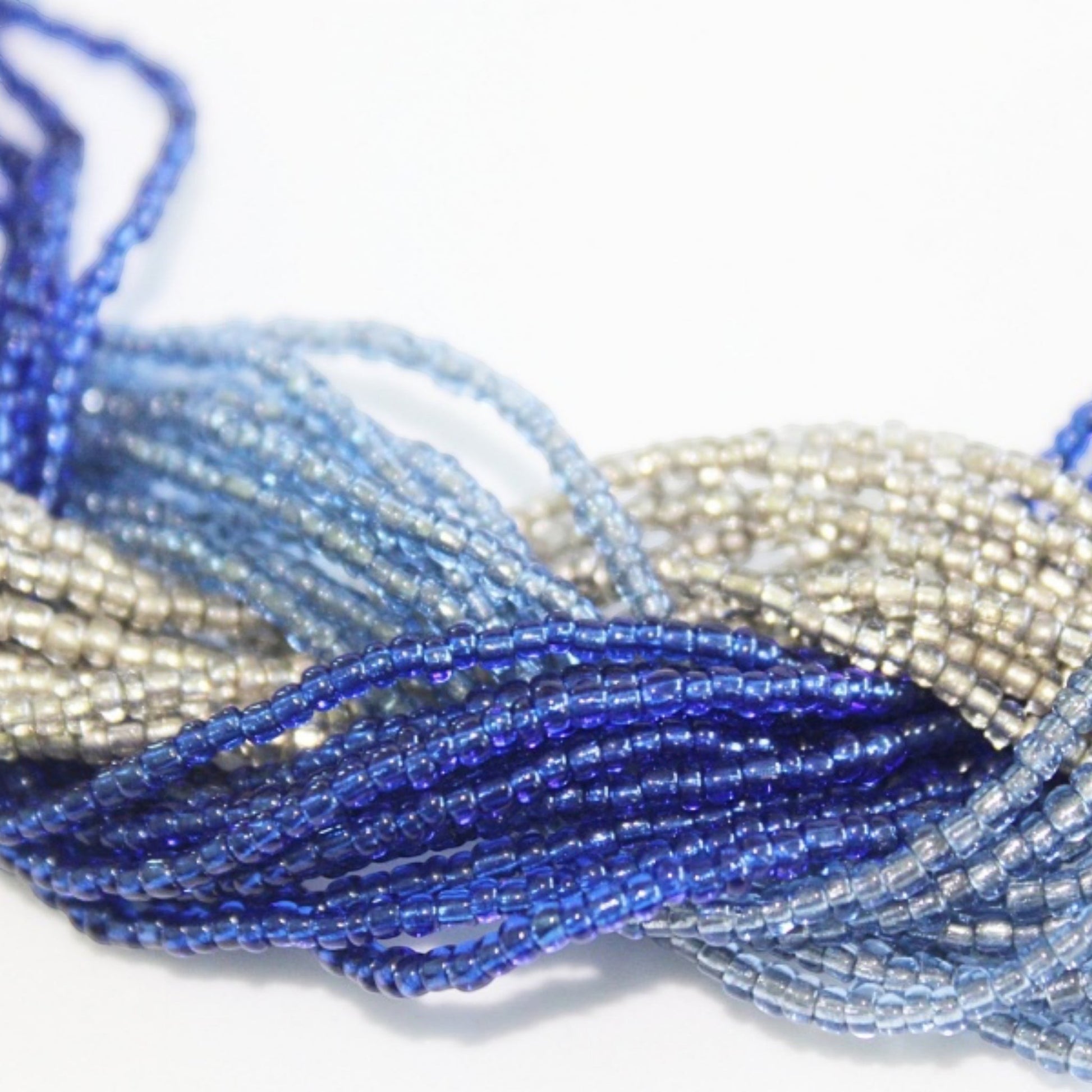 Jena Jewelry multi-strand braided necklace with glass seed beads in shades of blue and silver.
