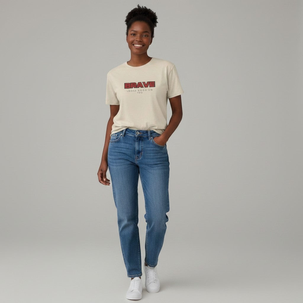 Jena Jewelry beige 100% cotton crewneck tee with red and black "BRAVE LOOKS GOOD ON YOU" graphic.