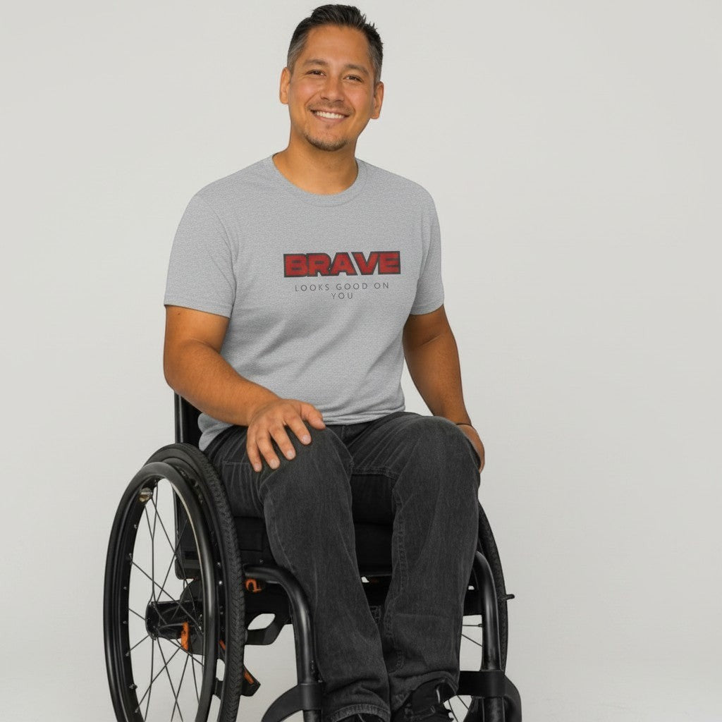 Jena Jewelry grey 100% cotton crewneck t-shirt with bold red "BRAVE" graphic and smaller text "LOOKS GOOD ON YOU".