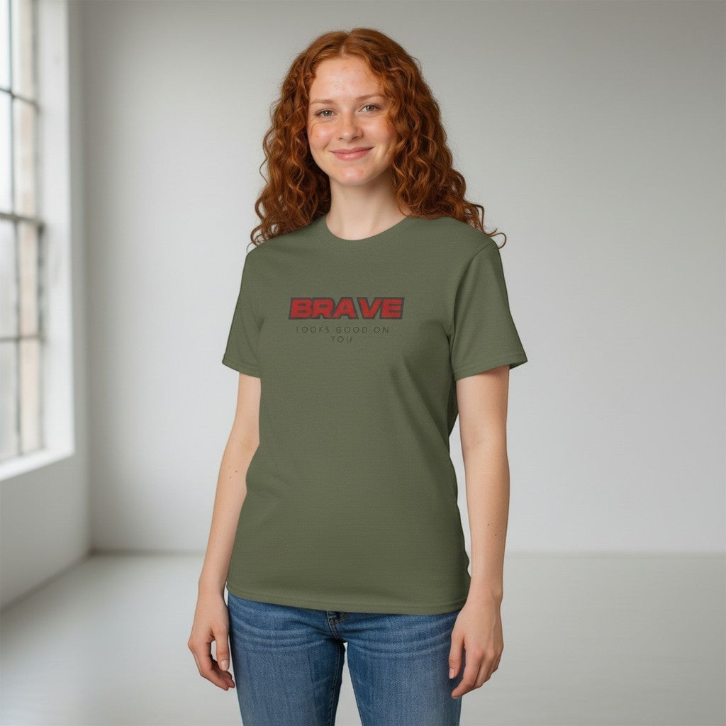 Jena Jewelry olive green cotton crewneck t-shirt with bold red "BRAVE" graphic and smaller "LOOKS GOOD ON YOU" text.