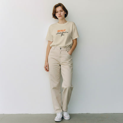 Jena Jewelry beige 100% cotton t-shirt with "BRAVE Looks Good on You" graphic print. Relaxed fit, crew neck.