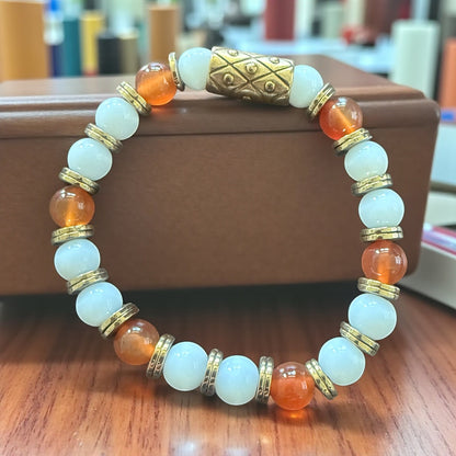 Jena Jewelry Carnelian, Snow Jade & Hematite stretch bracelet with gold accents. Features orange carnelian, white jade, and gold beads.