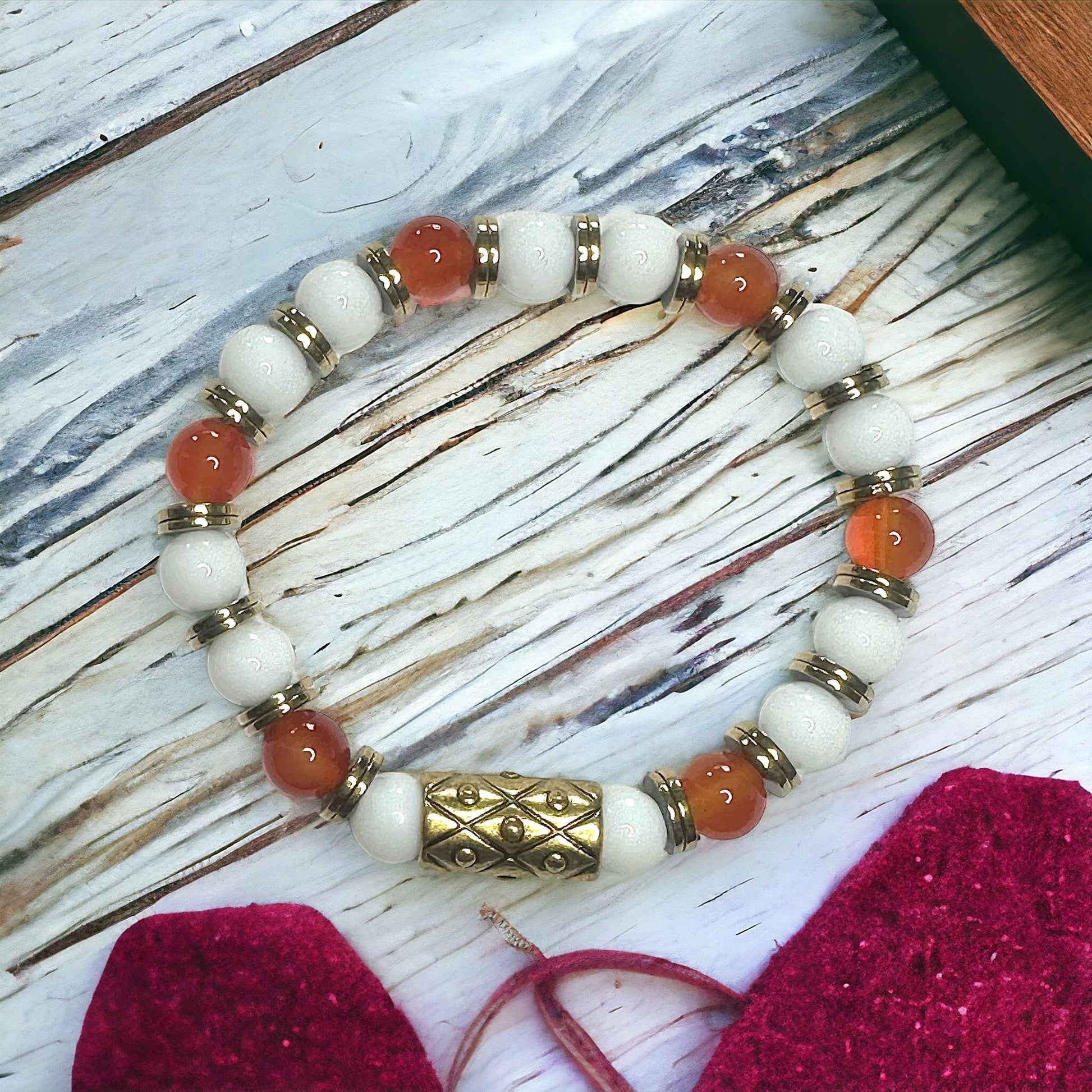 Jena Jewelry Carnelian, Snow Jade & Hematite stretch bracelet with gold accents and a central ornate bead.