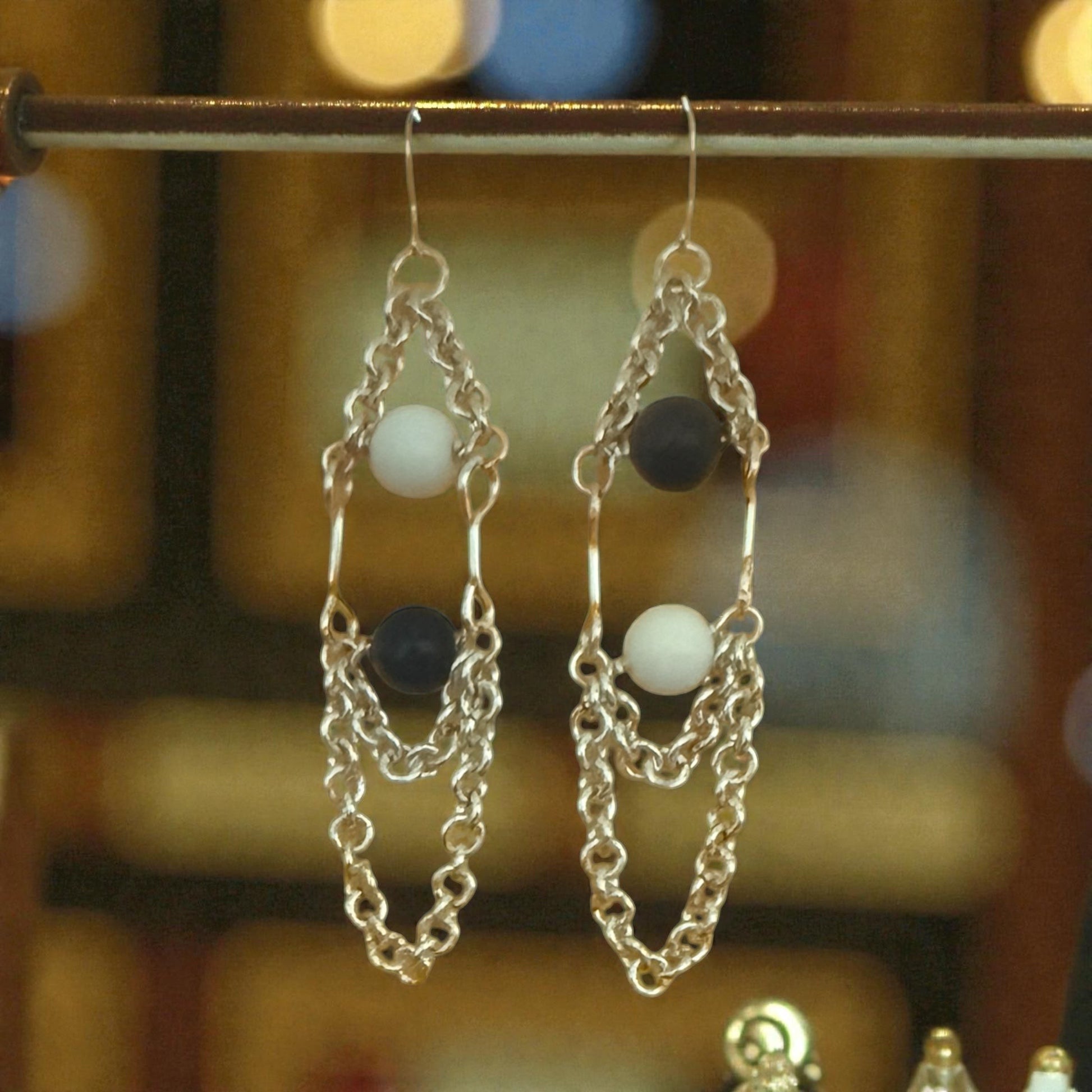 Jena Jewelry silver-filled chain link dangle earrings with white and black gemstone beads, 3-3.5 inches long.