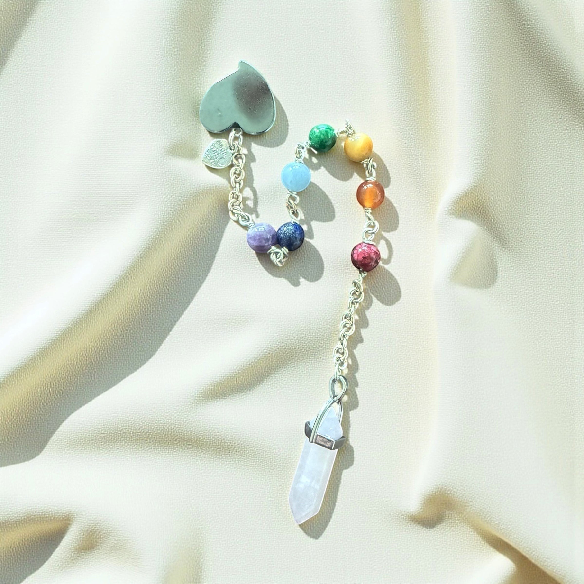 Jena Jewelry chakra healing pendulum with hematite heart, gemstone beads, and rose quartz point on a chainmaille handle.