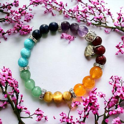 Jena Jewelry Chakra Stretch Bracelet with red, orange, yellow, green, blue, and purple gemstone beads and a silver heart charm.
