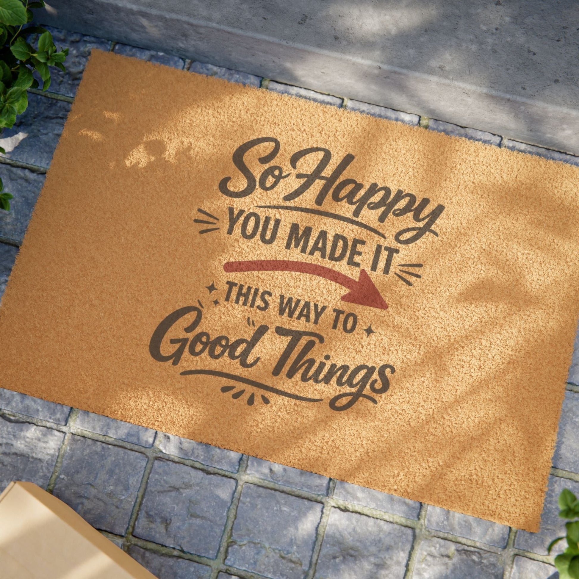 Jena Jewelry natural coir doormat with dark brown text "So Happy You Made It This Way To Good Things" and a red arrow.