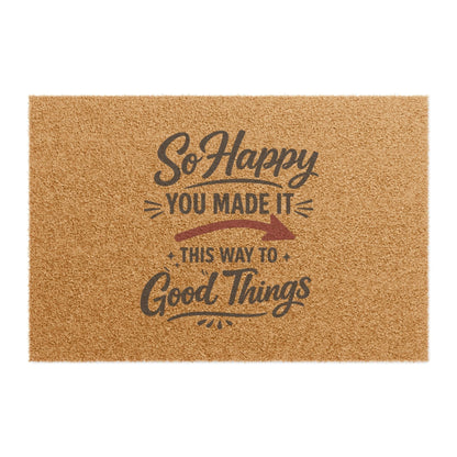 Jena Jewelry natural coir doormat with "So Happy You Made It This Way To Good Things" text in dark grey.