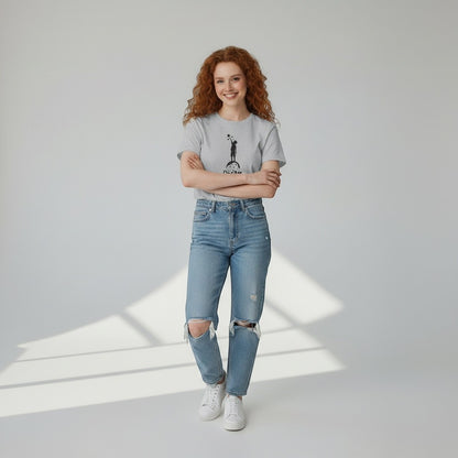 Jena Jewelry light grey cotton t-shirt with 'Dream Big' graphic of child reaching for stars. Model wears ripped jeans.