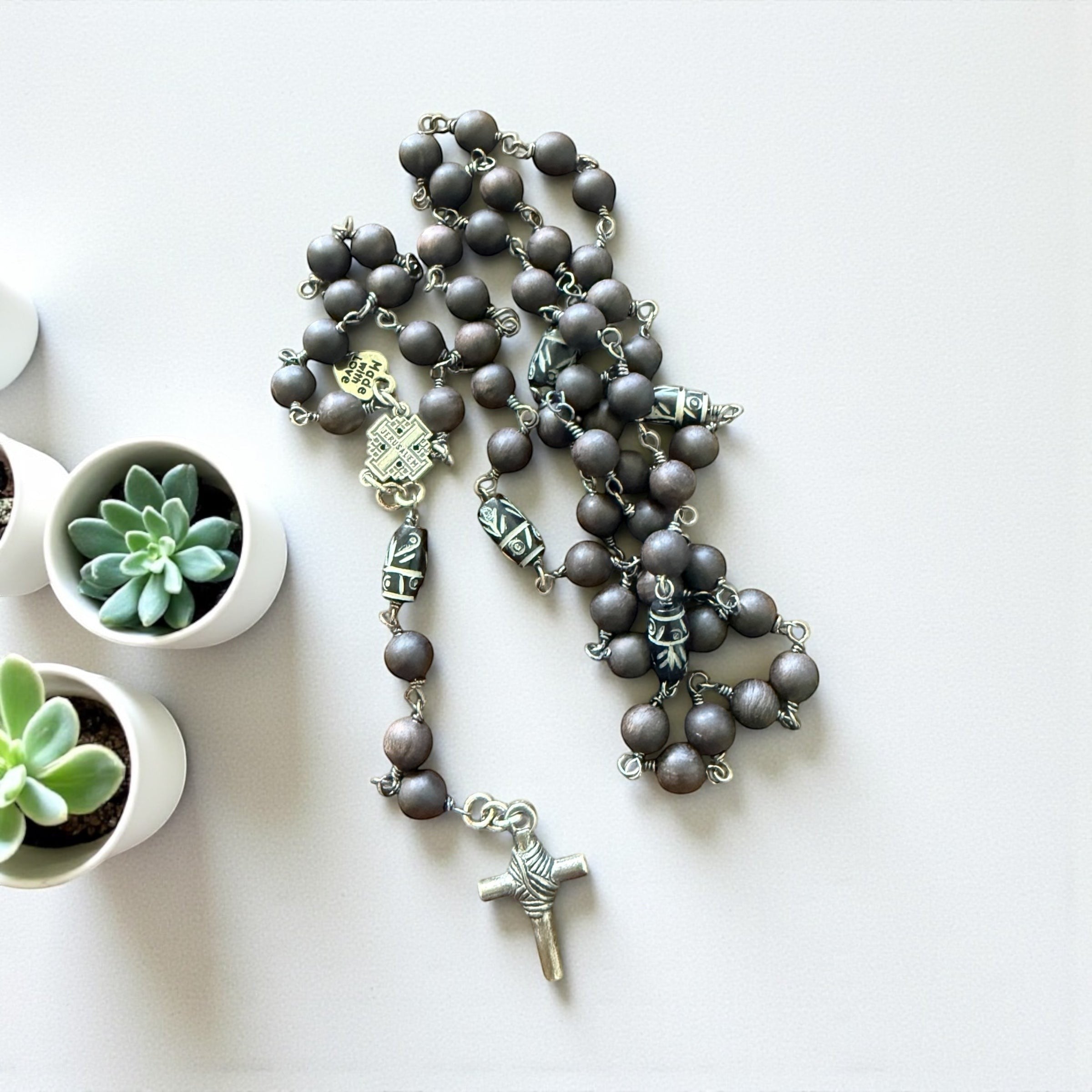 Jena Jewelry hand-wrapped rosary with dark ebony blackwood mala beads and hand-carved wood accent beads, finished with a base metal crucifix.