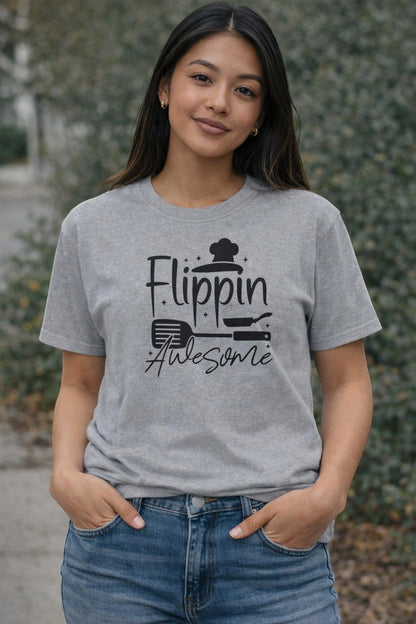 Jena Jewelry grey 100% cotton t-shirt with black graphic text 'Flippin' Awesome' and chef hat, spatula, and pan icons.
