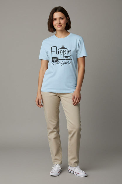 Jena Jewelry light blue 100% cotton t-shirt with black graphic print of a chef's spatula, frying pan, and pot with the text "Flippin' Awesome".