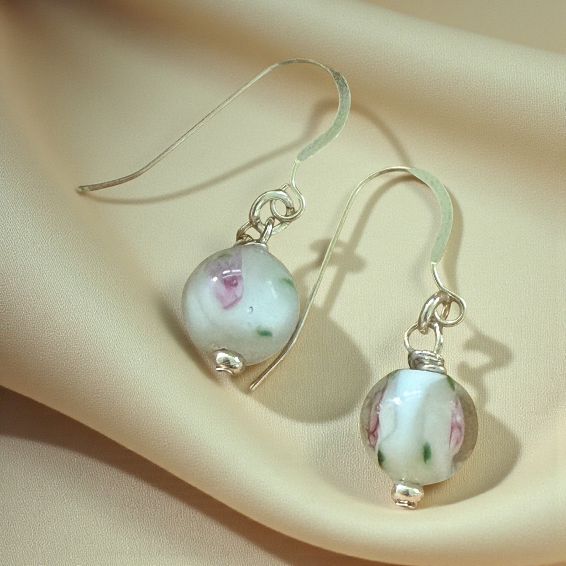Jena Jewelry handcrafted wire-wrapped earrings with antique floral lampwork glass beads and silver hooks.