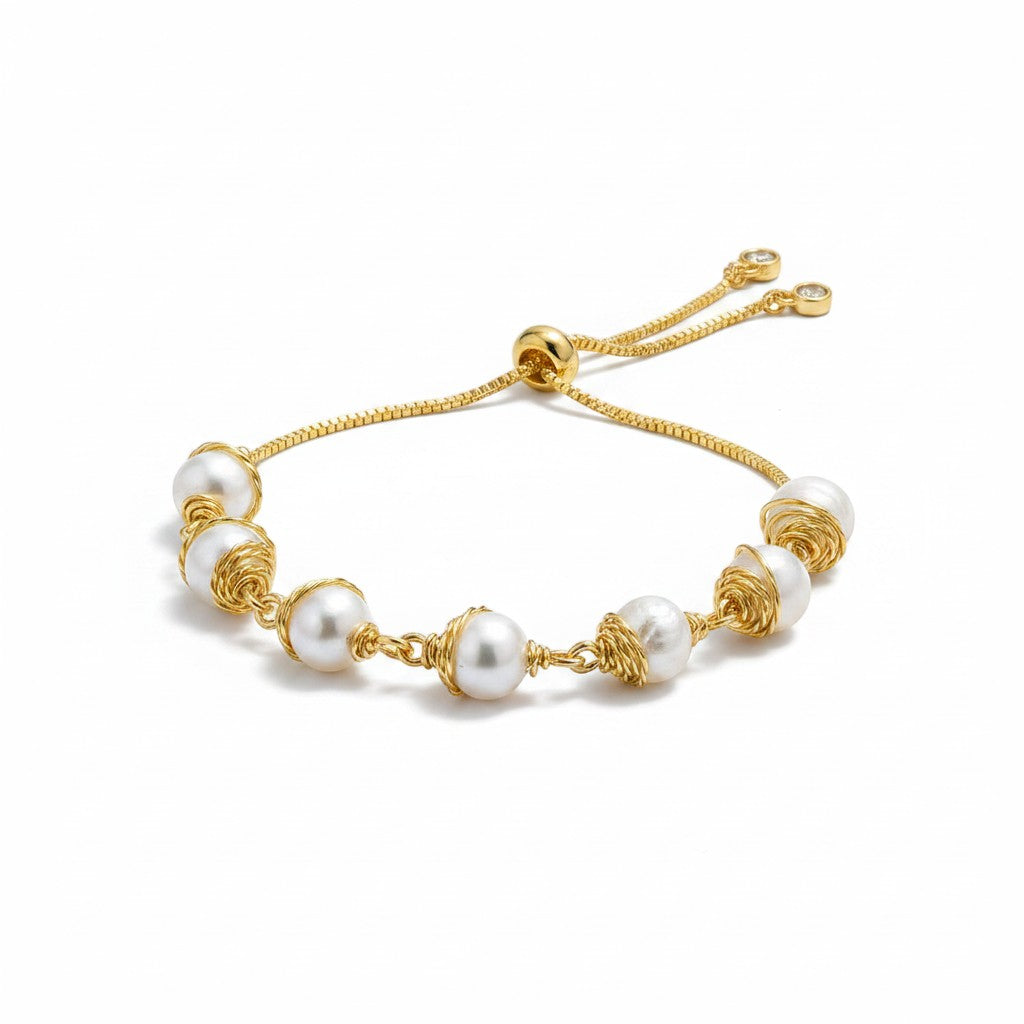 Jena Jewelry adjustable gold bracelet with six luminous freshwater pearls wire-wrapped and interspersed with gold beads on a delicate chain.