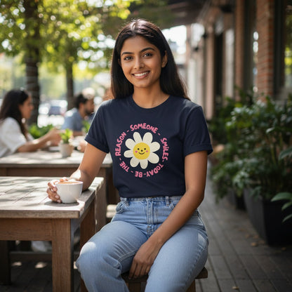Jena Jewelry navy blue 100% cotton t-shirt with a smiling daisy graphic and "Be the Reason Someone Smiles Today" text.