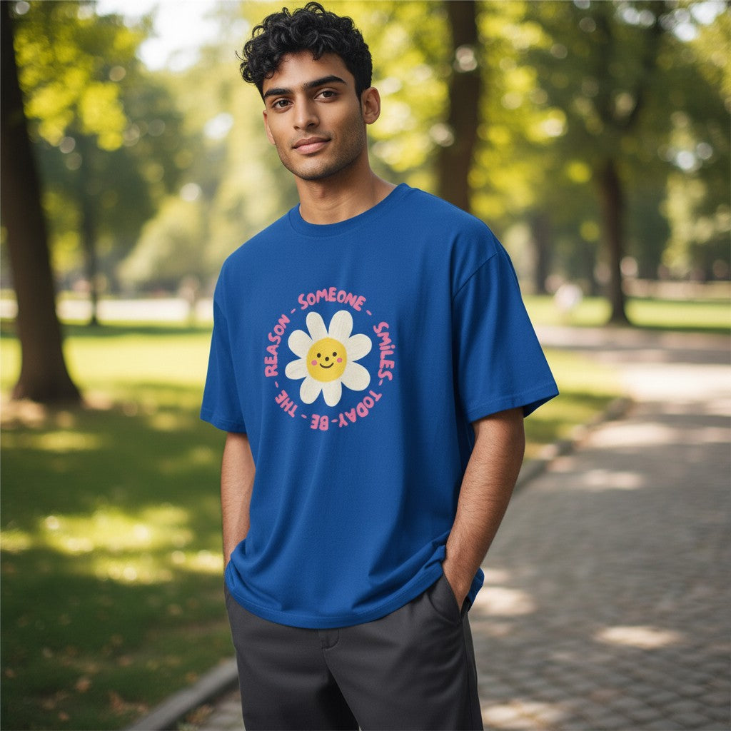 Jena Jewelry royal blue 100% cotton t-shirt with a smiling daisy graphic and "Be the Reason Someone Smiles Today" text.