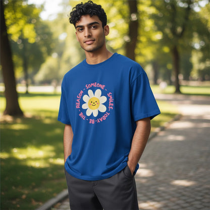 Jena Jewelry royal blue 100% cotton t-shirt with a smiling daisy graphic and "Be the Reason Someone Smiles Today" text.