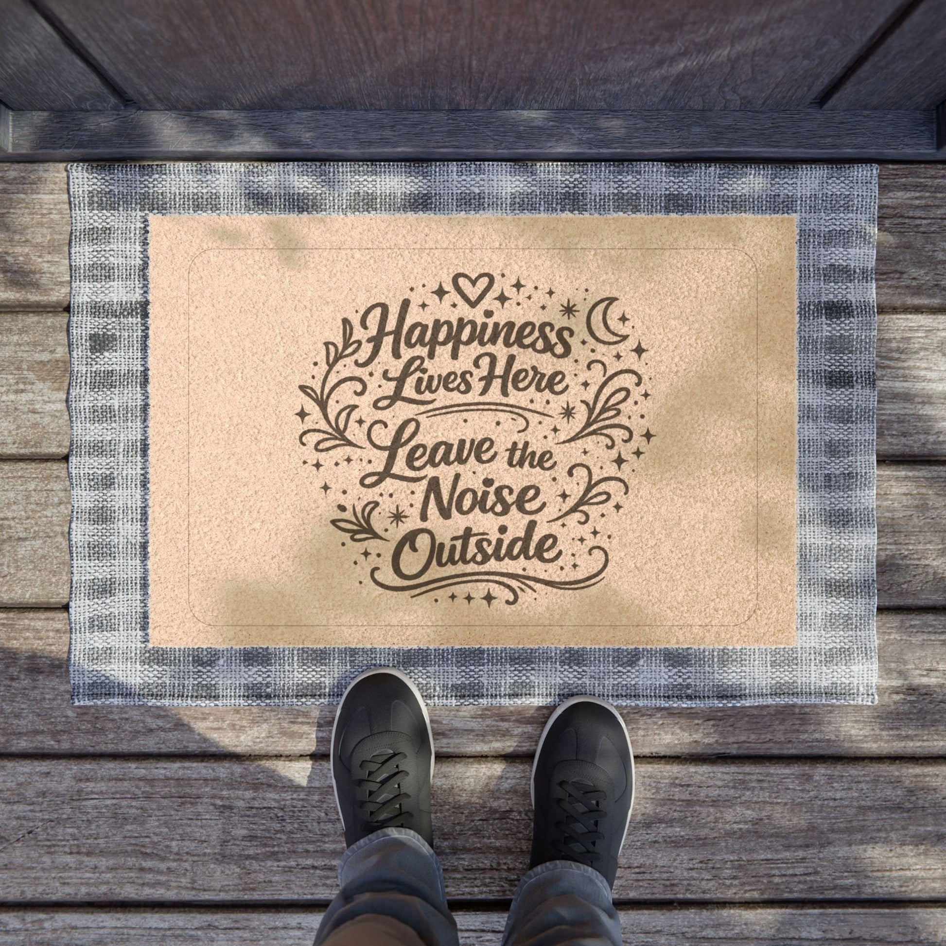 Jena Jewelry coir doormat with "Happiness Lives Here Leave the Noise Outside" text and decorative elements. Features a blue and white plaid border.