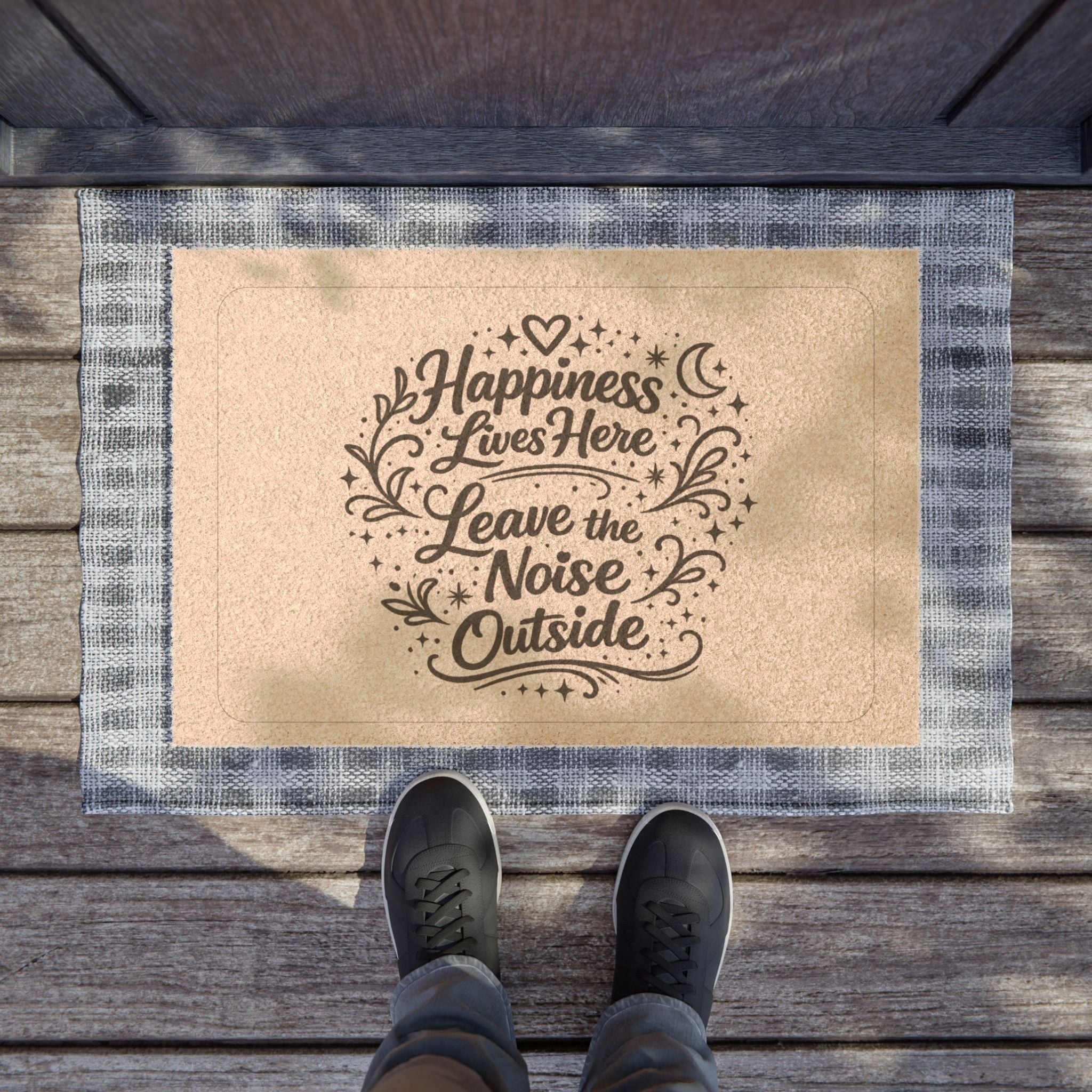 Jena Jewelry coir doormat with "Happiness Lives Here Leave the Noise Outside" text and decorative elements. Features a blue and white plaid border.