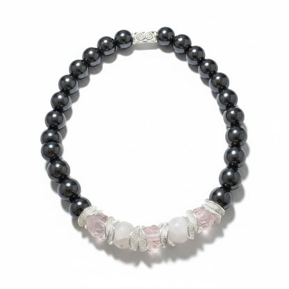 Jena Jewelry stretch bracelet with dark grey hematite beads and light pink rose quartz chips, accented with textured silver spacers.