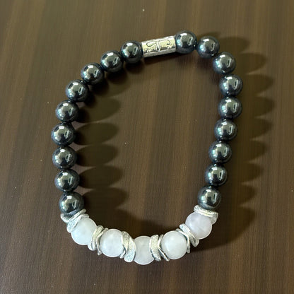 Jena Jewelry hematite and white quartz stretch bracelet with silver accents. Features metallic grey hematite beads and pale pink quartz beads.