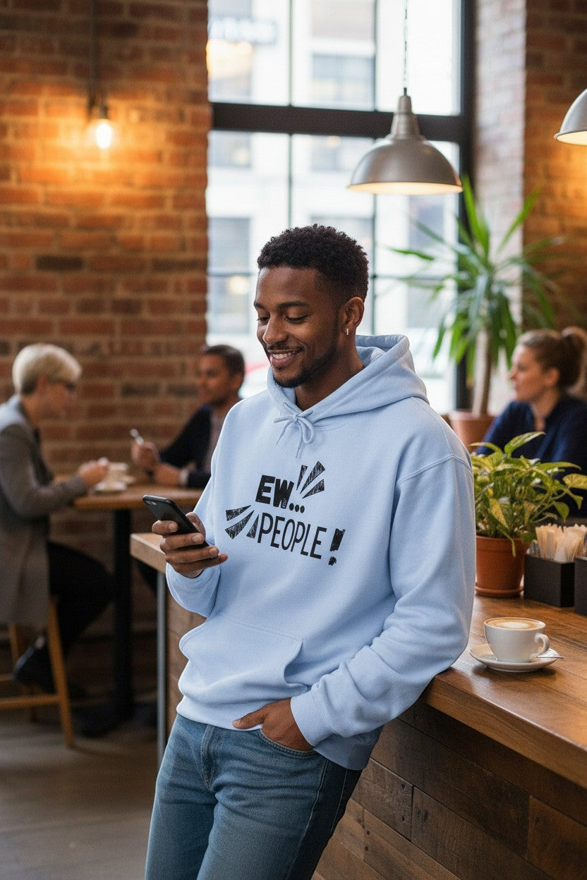 Light blue cotton-poly blend hoodie with a black distressed "EW... PEOPLE!" graphic print on the chest. Model leans against a counter, looking at his phone.