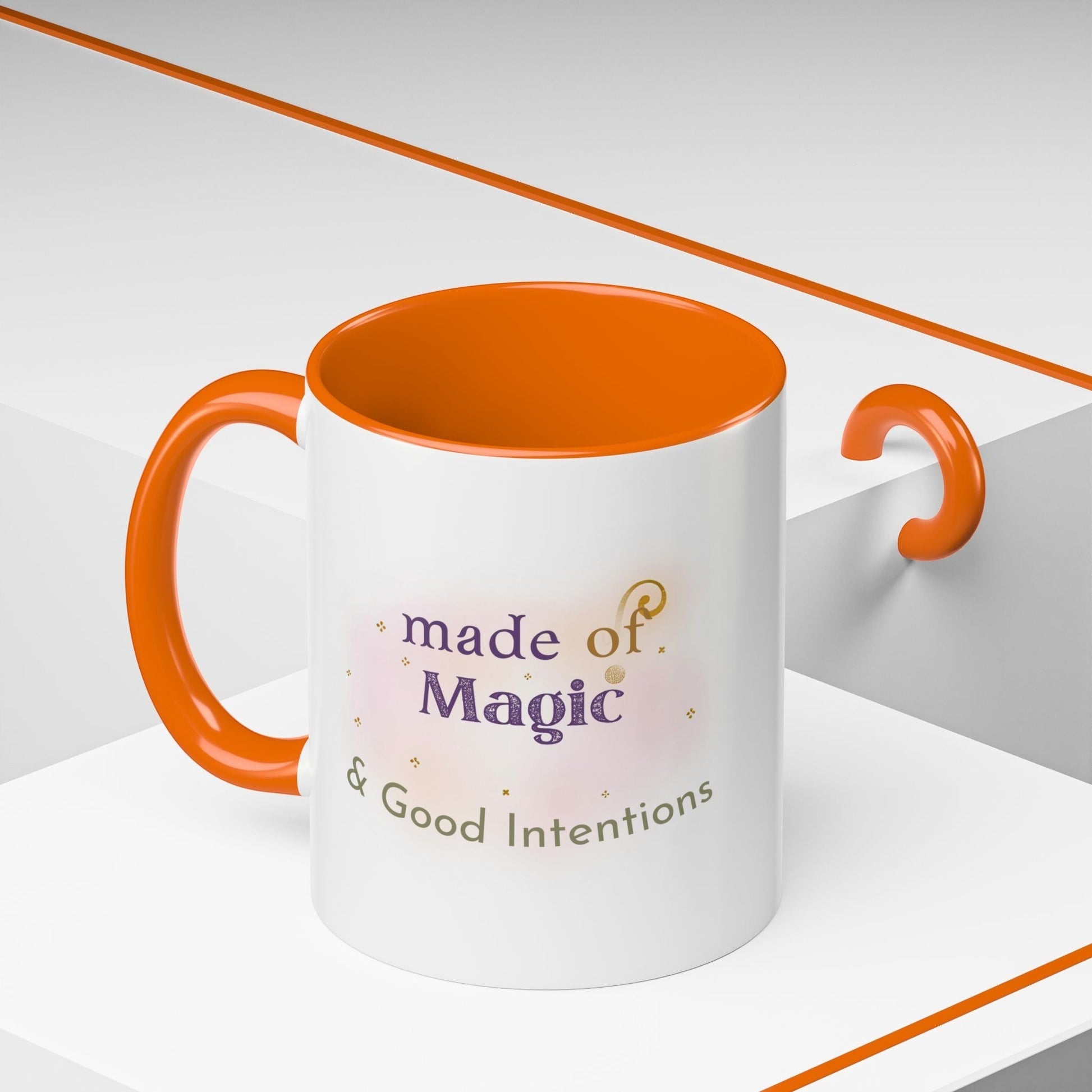 Jena Jewelry white ceramic mug with orange interior and handle, featuring "made of Magic & Good Intentions" text.