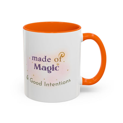 Jena Jewelry white ceramic mug with orange interior and handle, featuring "made of Magic & Good Intentions" text and watercolor accents.