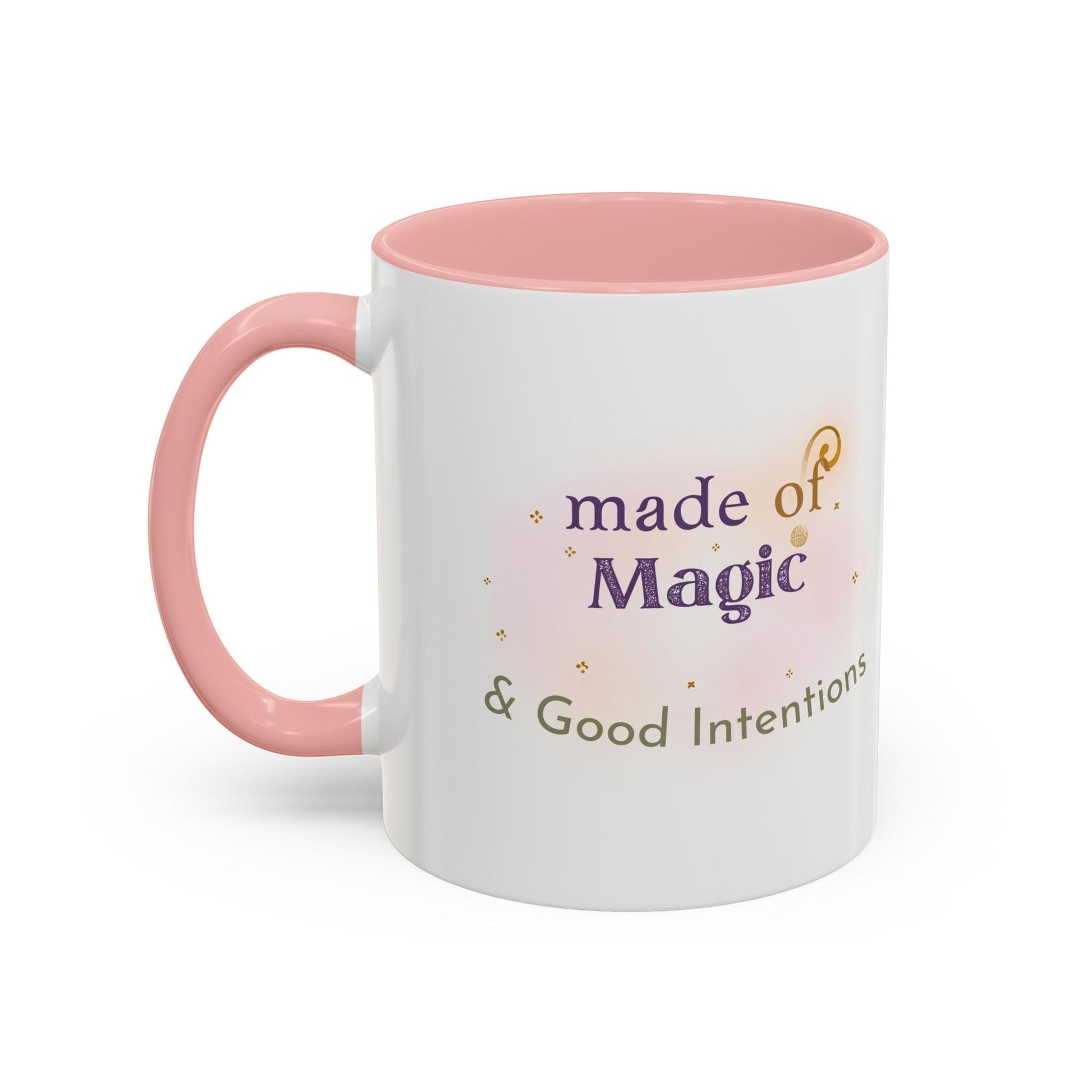 Jena Jewelry white ceramic mug with pink handle and interior, featuring the text "made of Magic & Good Intentions" in purple and green.