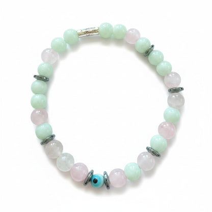 Jena Jewelry bracelet with light green jade, pink rose quartz, and hematite beads spelling 'F*ck Off' in Morse code. Features a central blue evil eye bead.