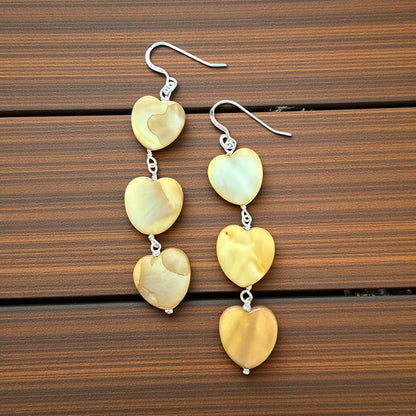 Jena Jewelry tea-dyed mother of pearl heart dangle earrings with silver hooks. Natural, feminine grace.