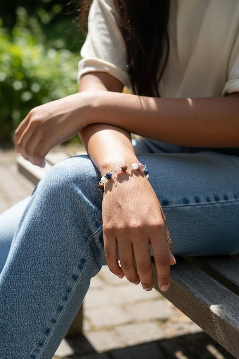 Jena Jewelry hand-wrapped multi-stone bracelet with blue, pink, and brown stones on a woman's wrist.