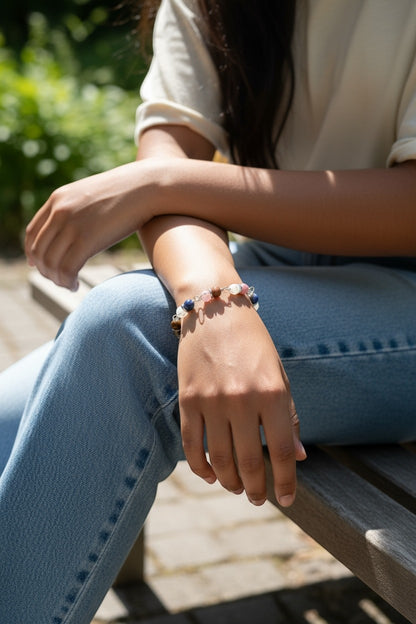 Jena Jewelry hand-wrapped multi-stone bracelet with blue, pink, and brown stones on a woman's wrist.