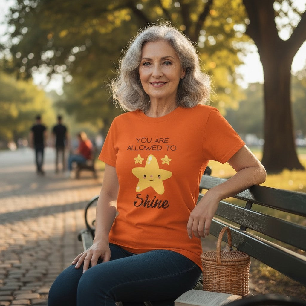 Jena Jewelry orange 100% cotton t-shirt with "You Are Allowed to Shine" graphic and smiling star.