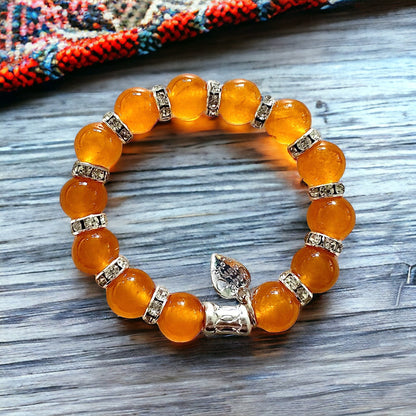 Jena Jewelry orange jade beaded bracelet with rhinestone spacers and silver charms. Stretch fit.