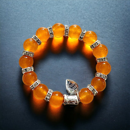 Jena Jewelry orange jade beaded bracelet with rhinestone spacers and a silver charm. Stretch fit.