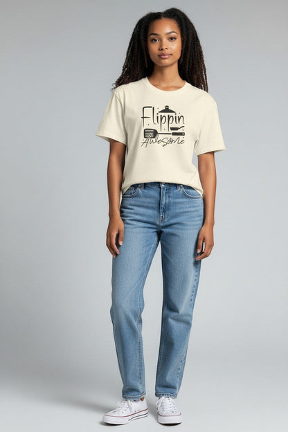 Jena Jewelry cream 100% cotton t-shirt with "Flippin' Awesome" graphic and kitchen utensil icons.