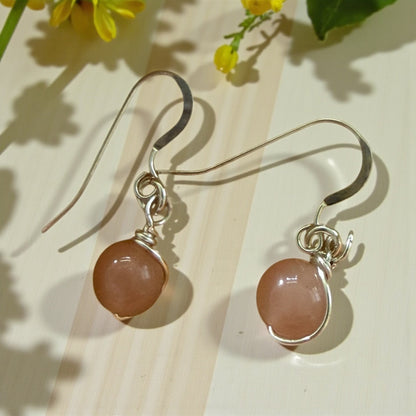 Jena Jewelry handcrafted wire-wrapped peach moonstone dangle earrings with silver hooks.