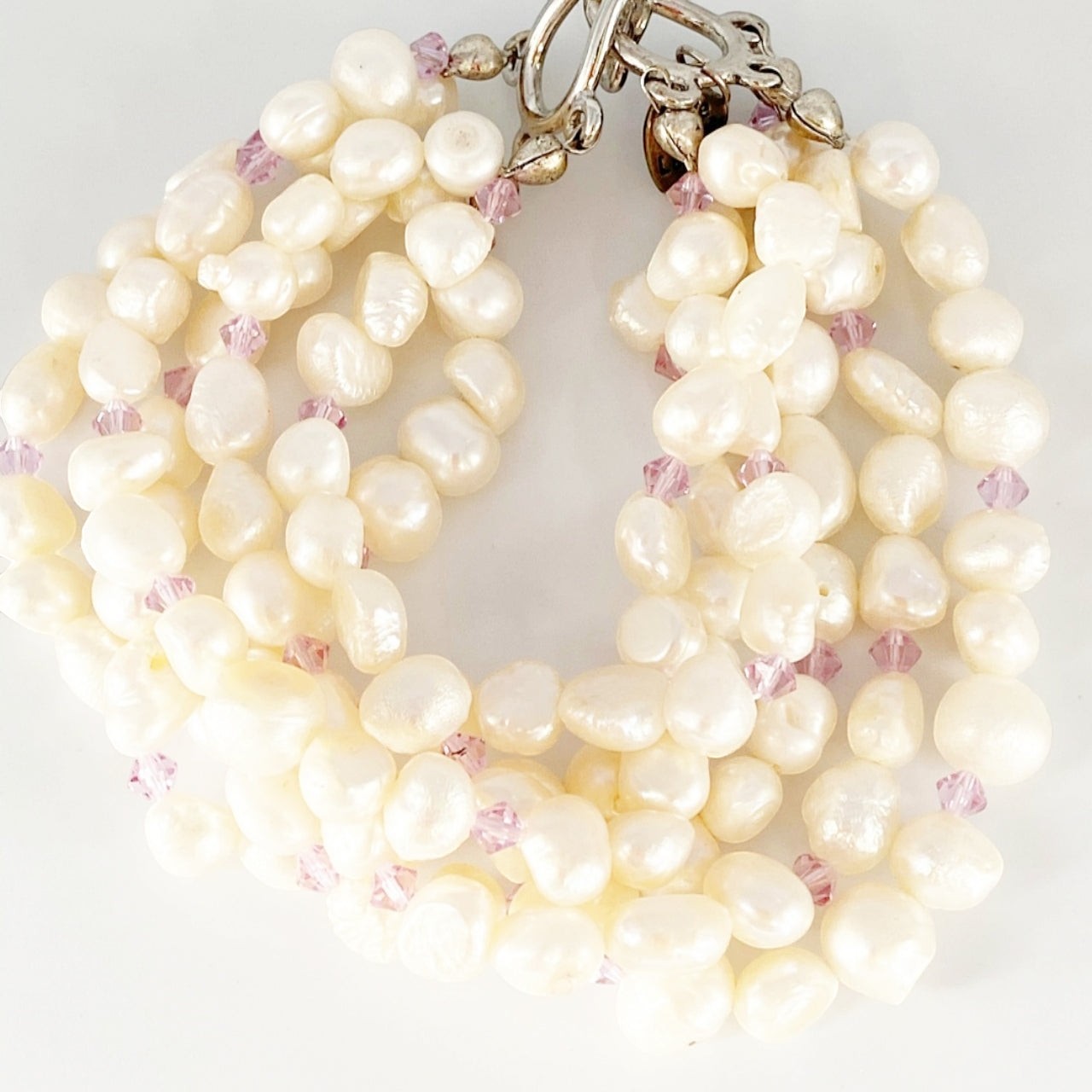 Jena Jewelry 6-strand freshwater pearl bracelet with purple crystals and silver toggle clasp. Classic bridal jewelry.