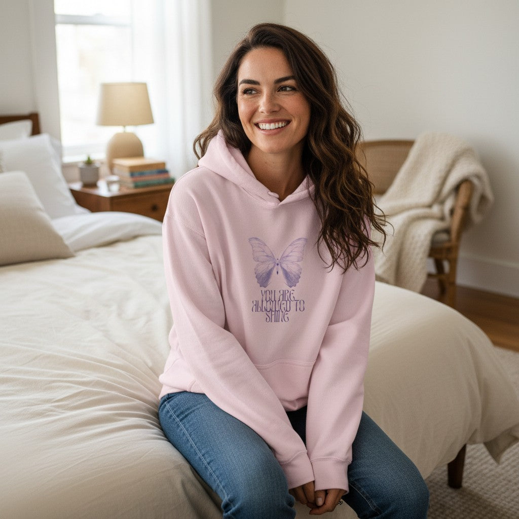Jena Jewelry light pink cotton-polyester blend hoodie with a faded lavender butterfly graphic and text "And Then She Almost Forgot" on the chest.