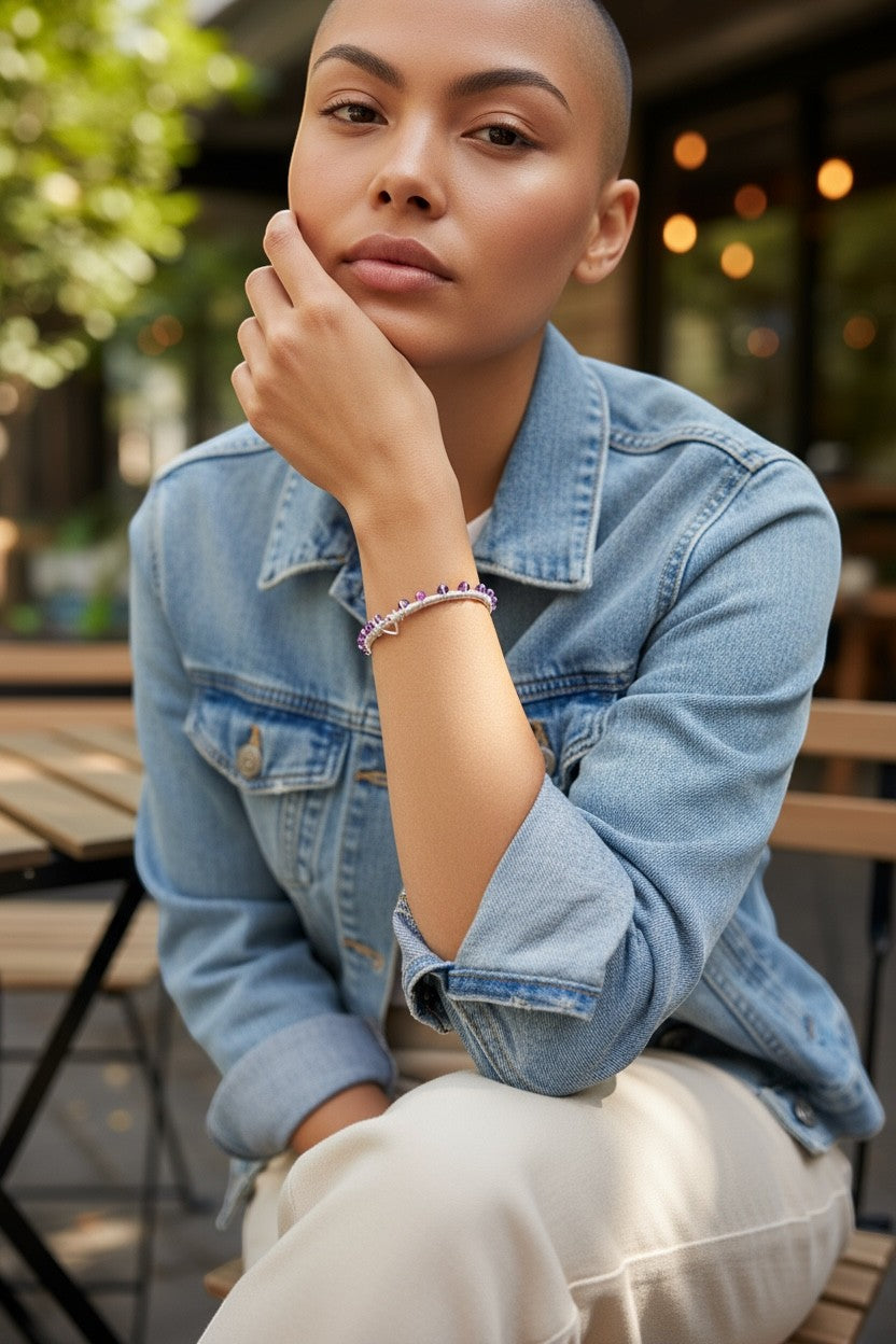Jena Jewelry wire-wrapped bangle bracelet with pink and purple crystals and a heart clasp on a model's wrist.