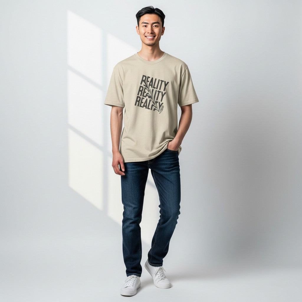 Jena Jewelry beige 100% cotton t-shirt with distressed diagonal "REALITY" graphic print and a small heart detail on the collar.