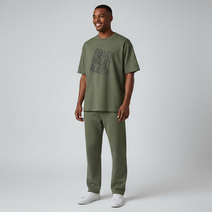Jena Jewelry olive green cotton t-shirt with distressed diagonal "REALITY" graphic print and crew neck.