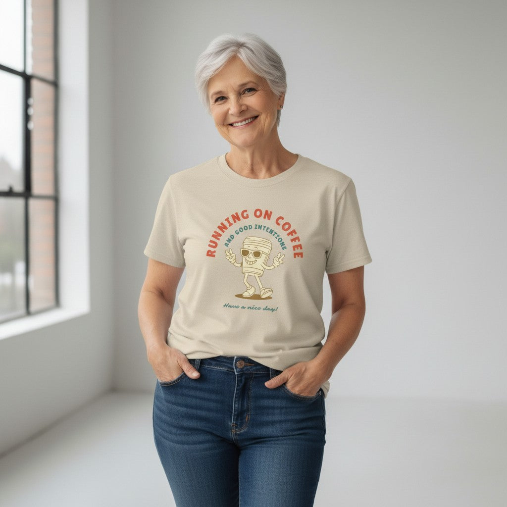 Jena Jewelry beige 100% cotton t-shirt with a retro graphic of a smiling coffee cup wearing sunglasses and giving peace signs, text reads "RUNNING ON COFFEE AND GOOD INTENTIONS".